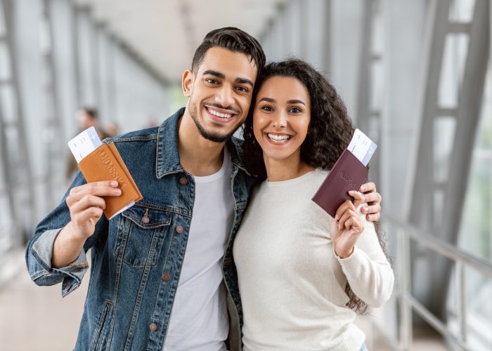 happy-travellers-young-arab-couple-with-passports-and-tickets-posing-at-airport.jpg